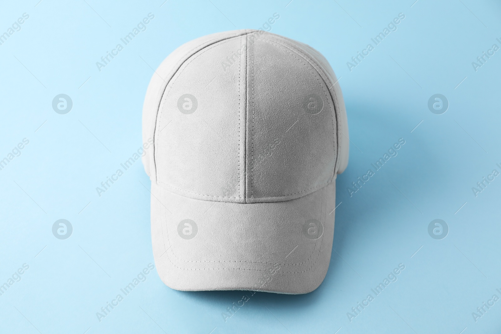 Photo of Stylish baseball cap on light blue background. Mockup for design