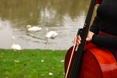 Woman with cello in park, closeup. Space for text