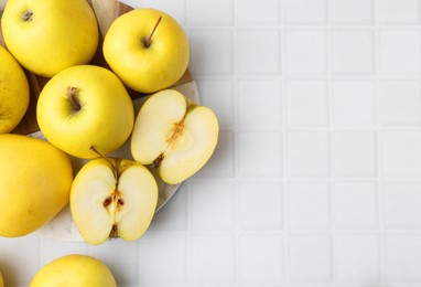 Photo of Fresh ripe yellow apples on white tiled table, flat lay. Space for text