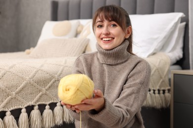 Photo of Beautiful woman with yellow yarn at home. Knitting material