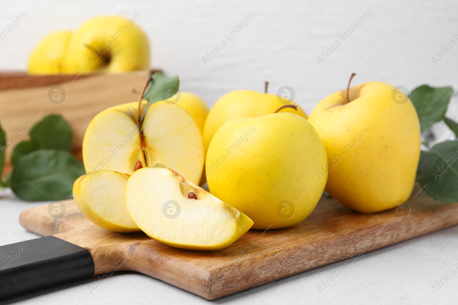 Photo of Ripe yellow apples on light grey table, closeup