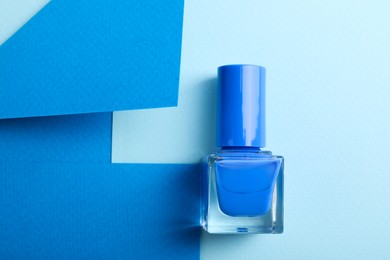 Photo of Nail polish in bottle on color background, top view. Space for text