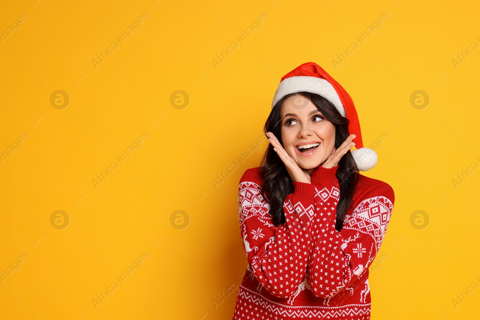 Photo of Beautiful woman in Santa hat and Christmas sweater on yellow background, space for text