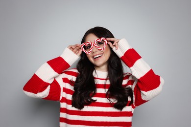 Photo of Happy woman with party glasses on light grey background. Christmas celebration