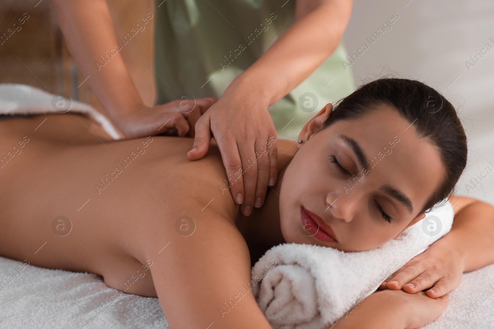 Photo of Young woman receiving massage in spa salon