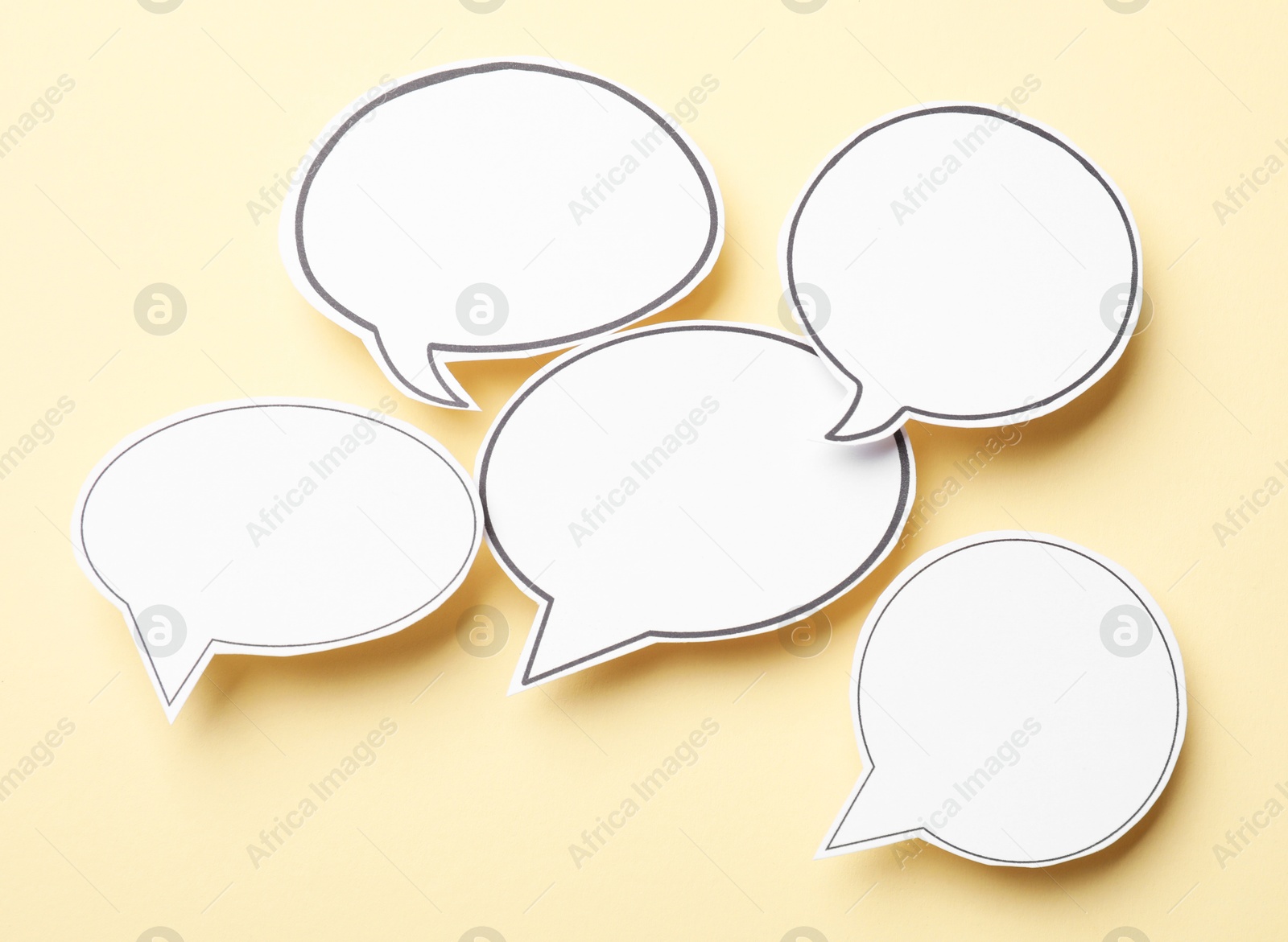 Photo of Blank speech bubbles on beige background, top view. Space for text