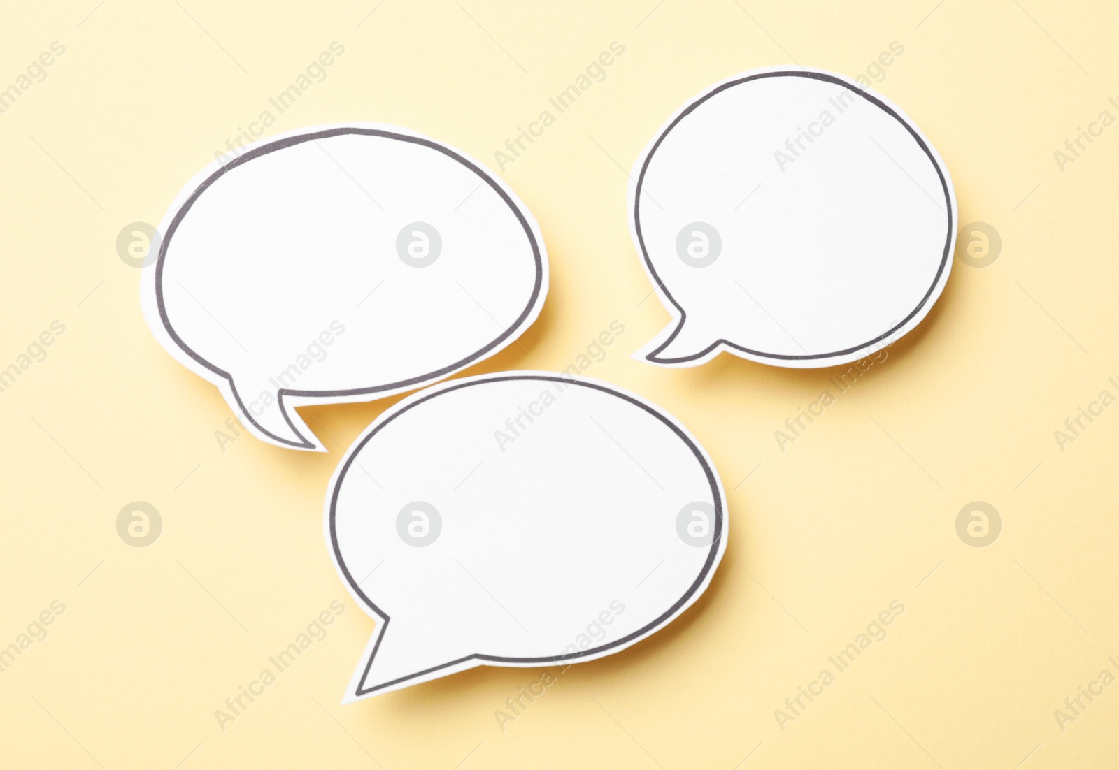 Photo of Blank speech bubbles on beige background, top view. Space for text