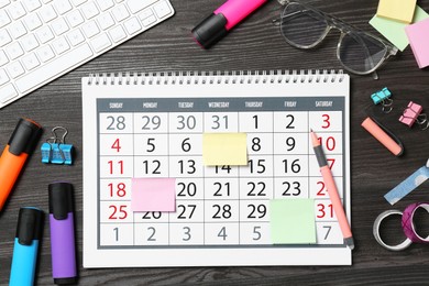 Photo of Timetable. Calendar, stationery and computer keyboard on wooden table, flat lay