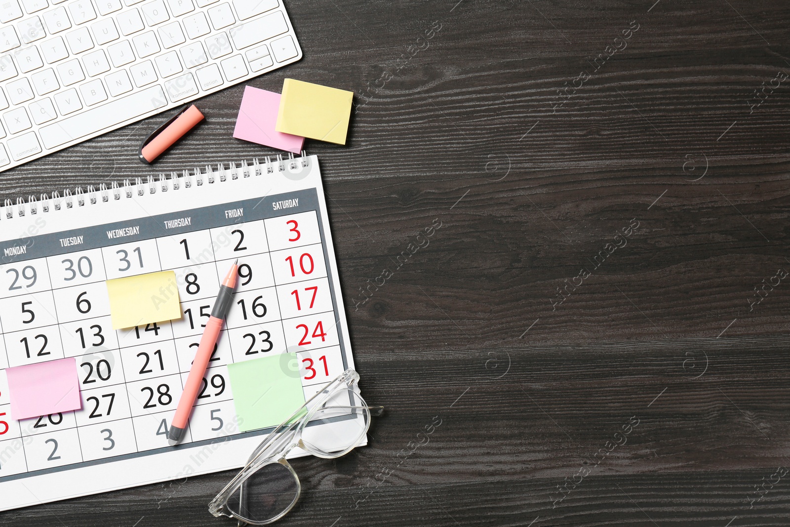 Photo of Timetable. Calendar, stationery and computer keyboard on wooden table, flat lay. Space for text