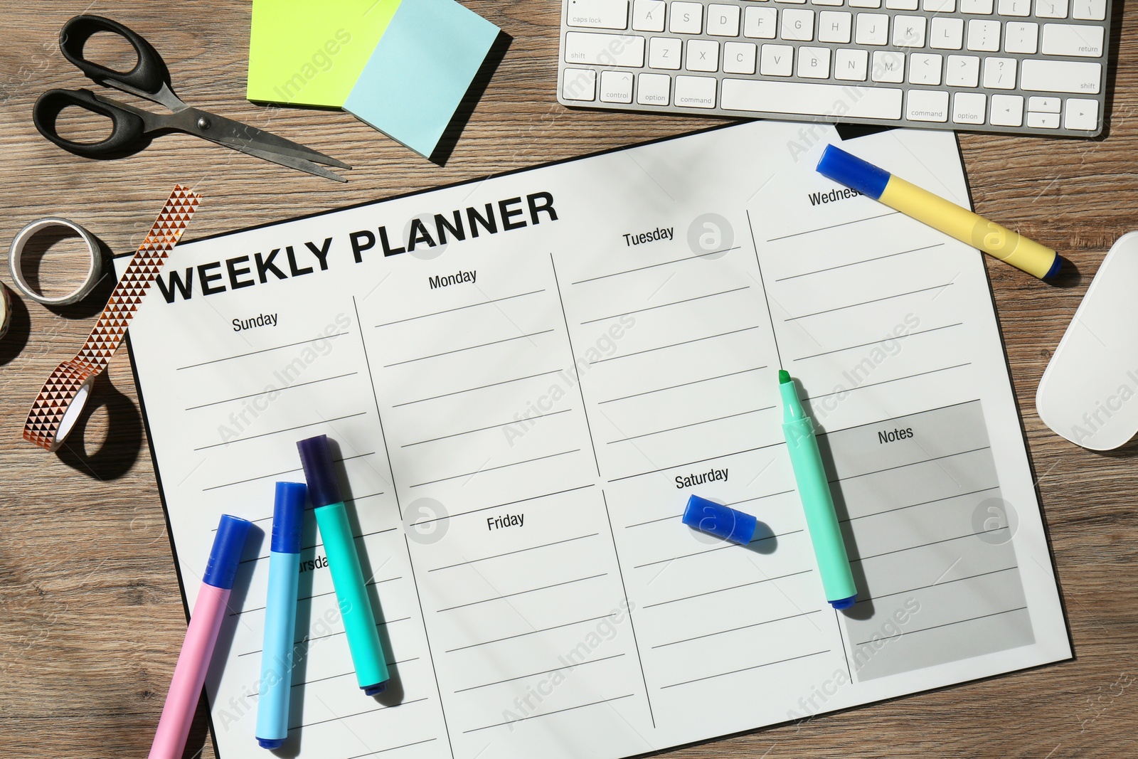 Photo of Timetable. Weekly planner, stationery and computer keyboard on wooden table, flat lay