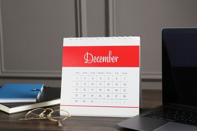 Photo of Timetable. Monthly planner, notebooks, laptop and glasses on wooden table