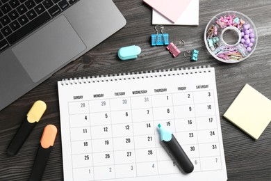 Timetable. Monthly planner, stationery and laptop on wooden table, flat lay