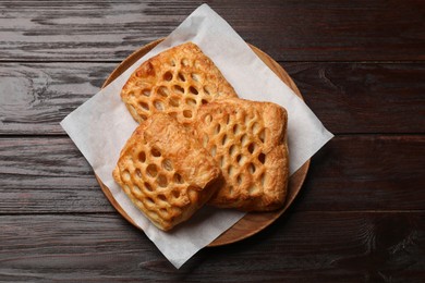 Photo of Delicious puff pastries with fruit filling on wooden table, top view