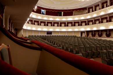 Rows of gray comfortable seats in theatre