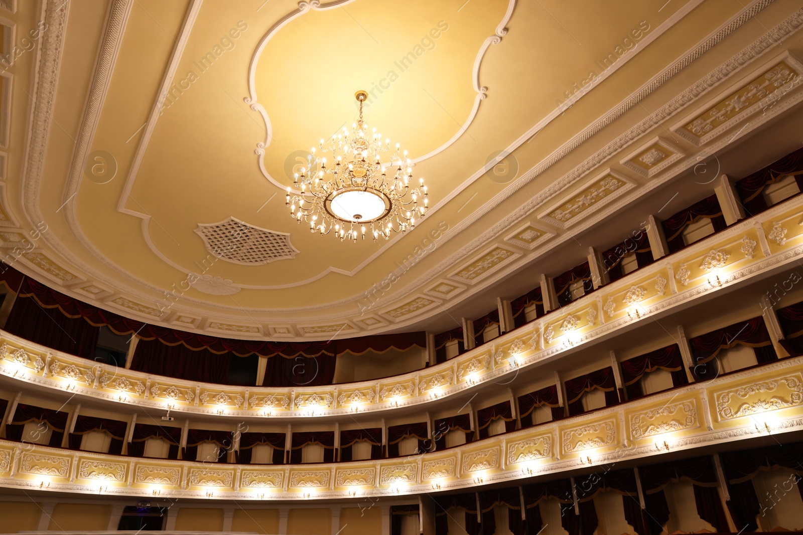 Photo of Stylish vintage chandelier in theatre, low angle view