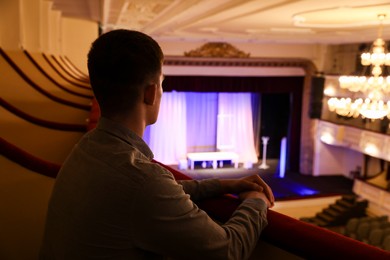 Photo of Young man watching theatrical performance in theatre