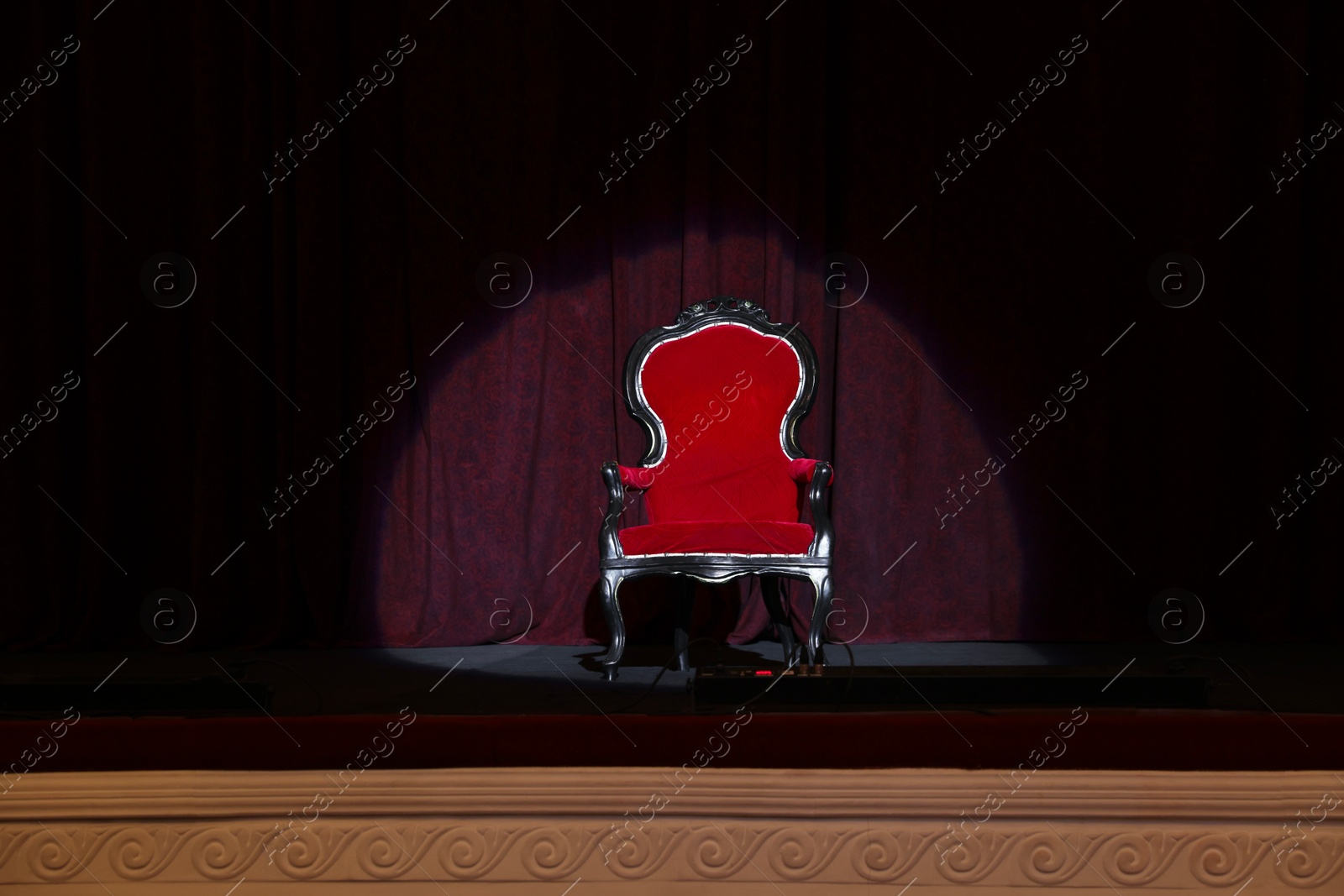 Photo of Vintage red armchair on stage in theatre