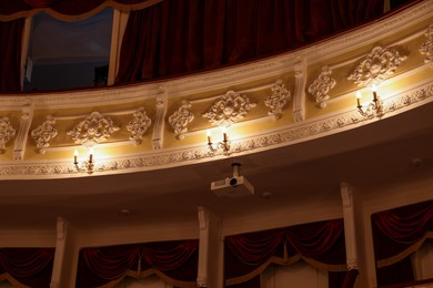 Photo of Modern projector and vintage lamps in theatre