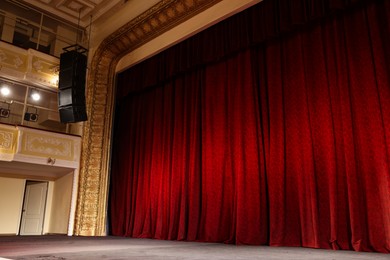 Photo of Elegant red curtains and spotlights in theatre