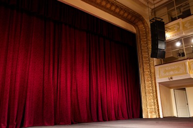 Photo of Elegant red curtains and spotlights in theatre