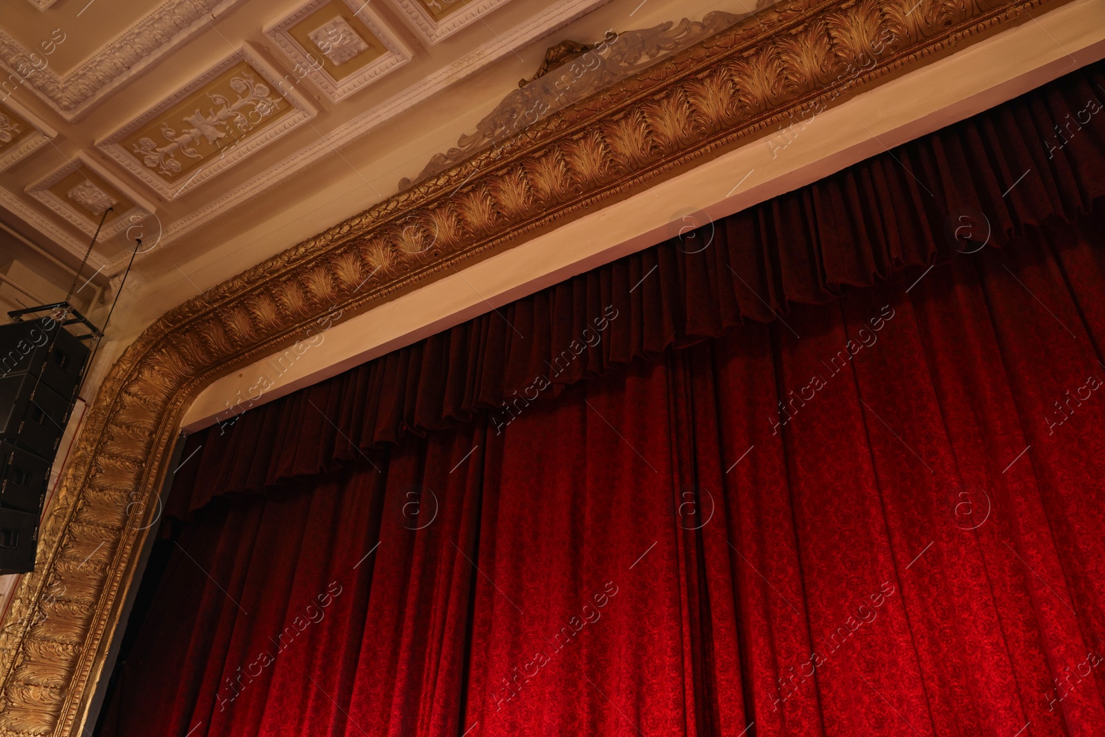 Photo of Elegant red curtains in theatre, low angle view