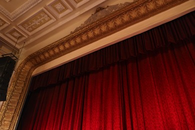 Photo of Elegant red curtains in theatre, low angle view