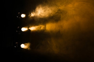 Photo of Professional spotlights and smoke on stage in theatre