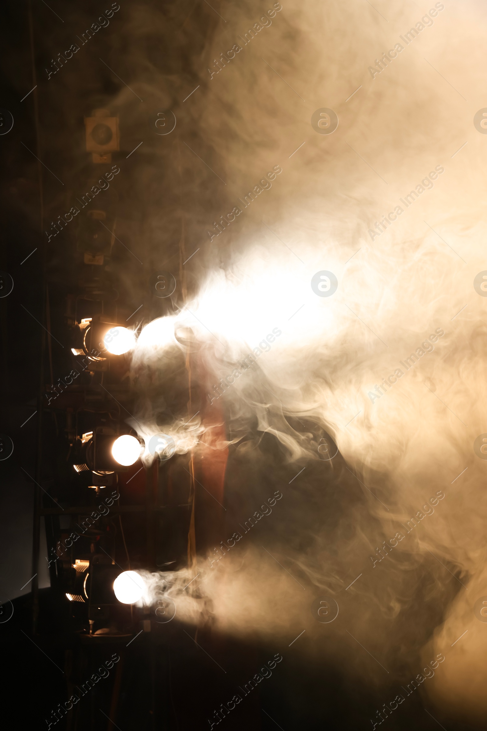 Photo of Professional spotlights and smoke on stage in theatre