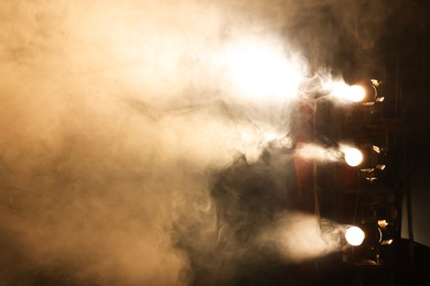 Photo of Professional spotlights and smoke on stage in theatre