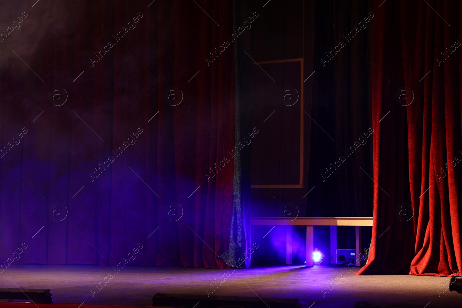 Photo of Professional spotlight and smoke on stage in theatre