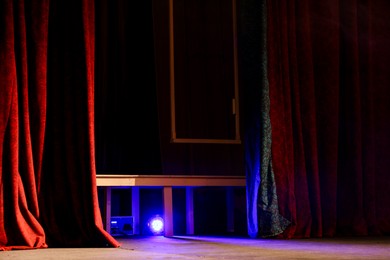 Photo of Professional spotlight under table on stage in theatre