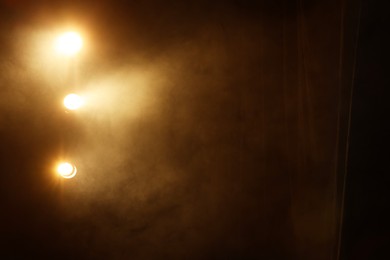 Photo of Professional spotlights and smoke on stage in theatre