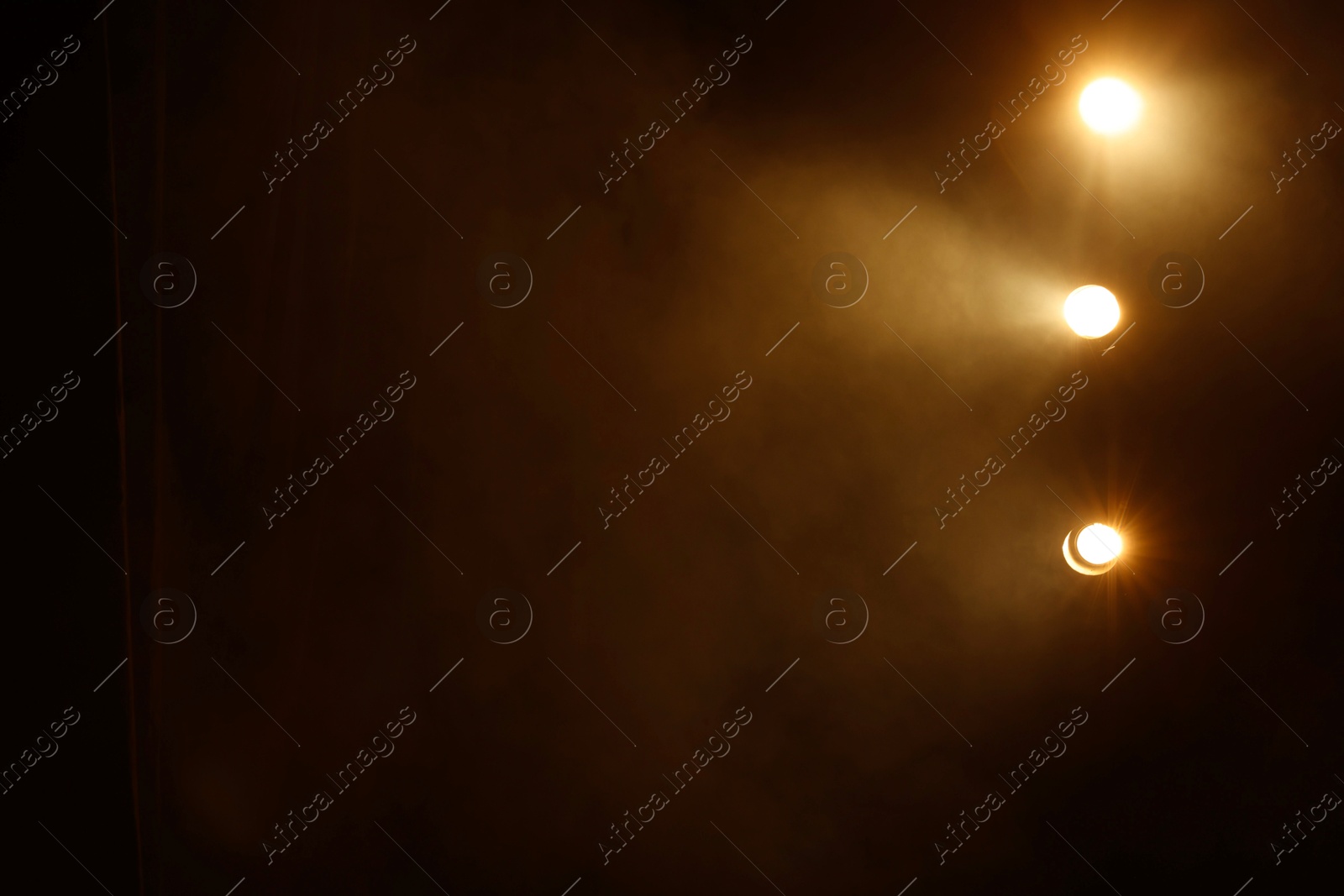 Photo of Professional spotlights and smoke on stage in theatre