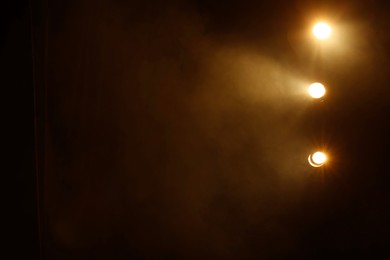 Photo of Professional spotlights and smoke on stage in theatre