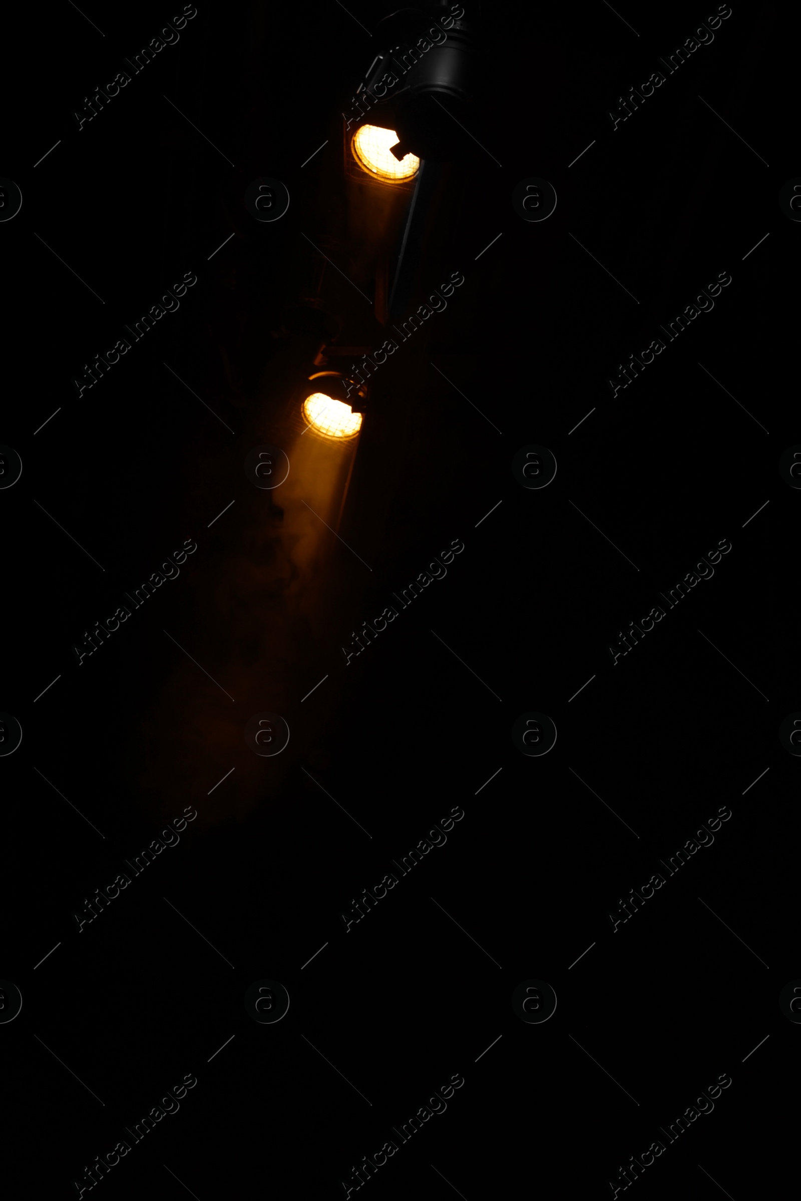 Photo of Professional spotlights against dark background in theatre