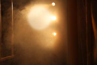 Photo of Professional spotlights and smoke on stage in theatre