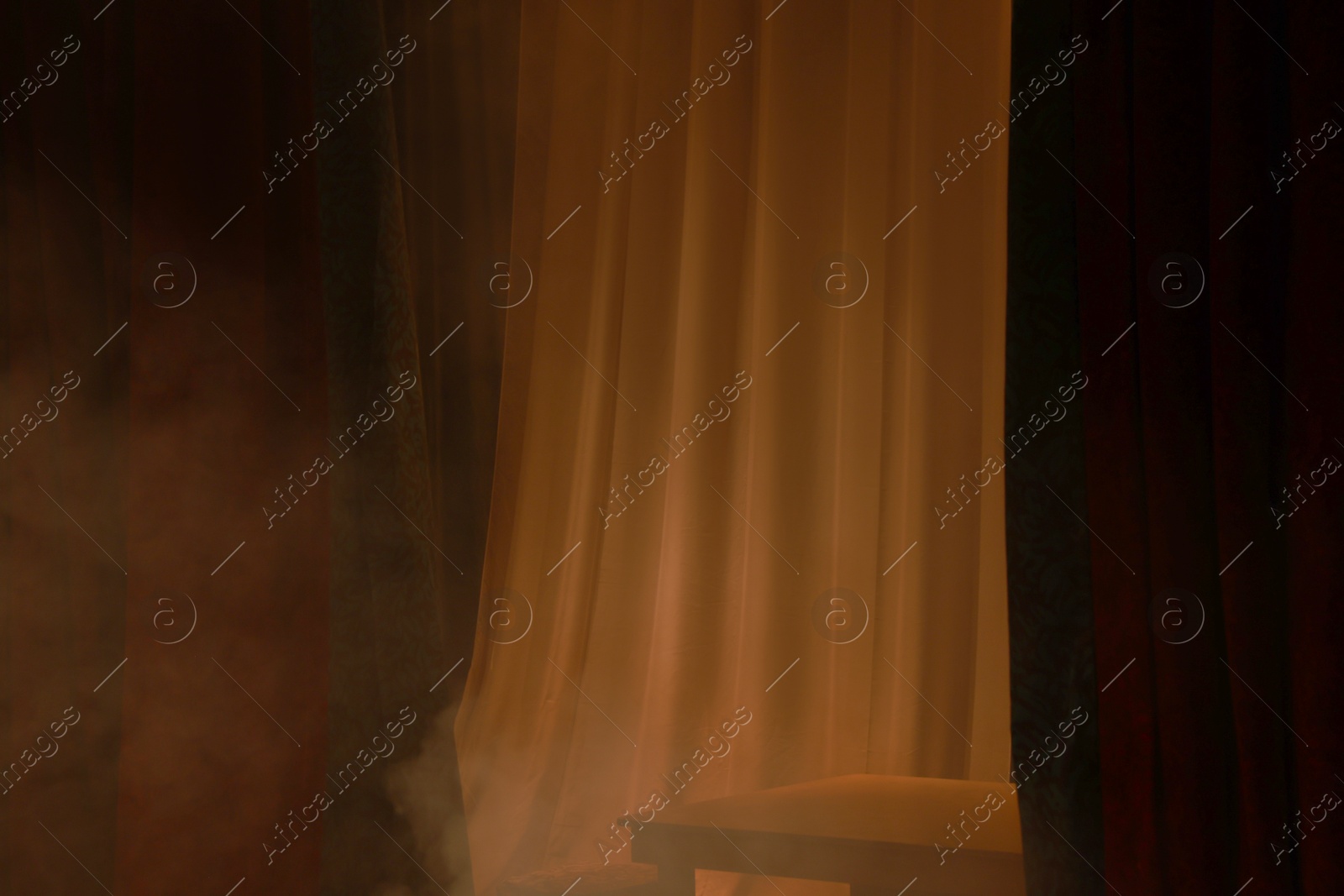 Photo of Dark curtains, tulle and table on stage in theatre