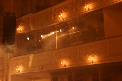 Photo of Professional spotlights and smoke in theatre, low angle view