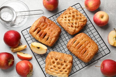 Photo of Delicious puff pastries with fruit filling and apples on grey table, top view