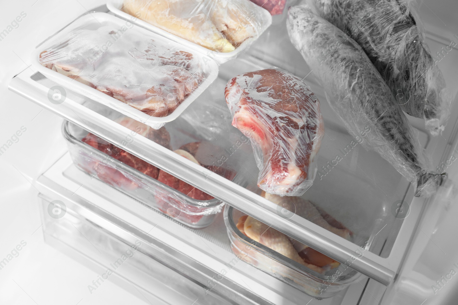 Photo of Different frozen meat and fish products in fridge, closeup