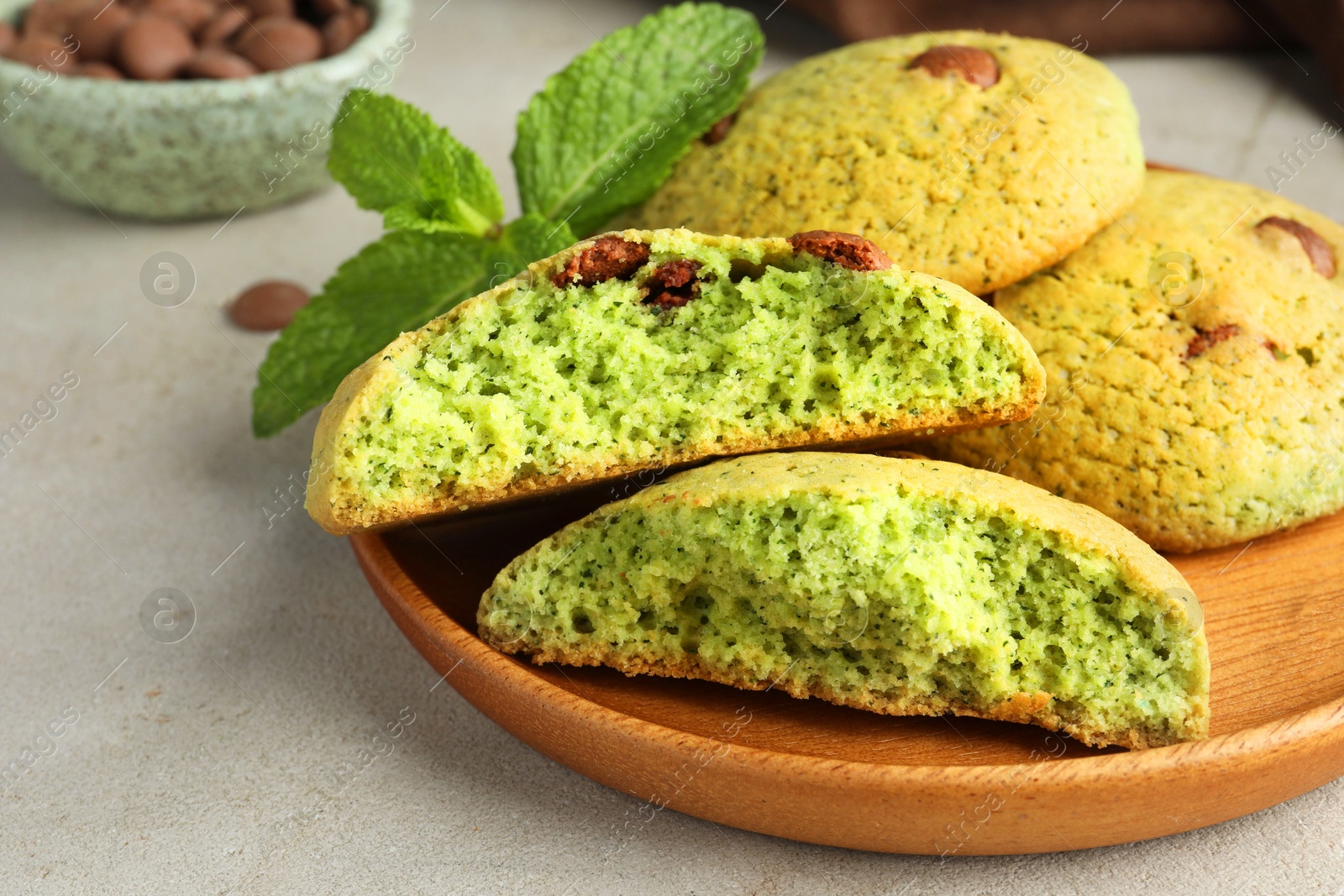 Photo of Delicious mint chocolate chip cookies on light table, closeup