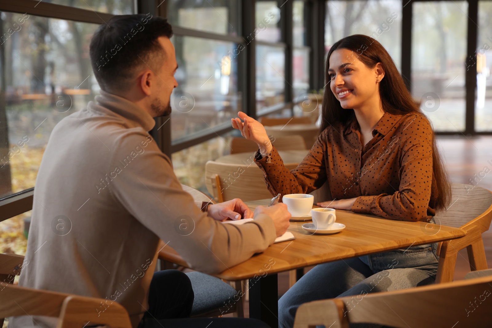 Photo of Colleagues working together at table in cafe