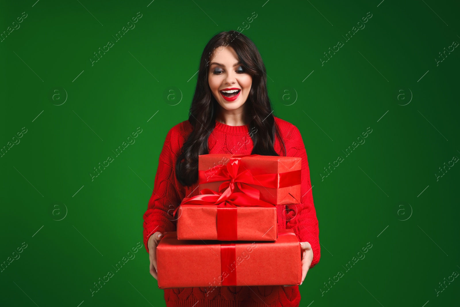 Photo of Beautiful woman with Christmas gifts on green background