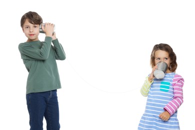 Photo of Boy and girl talking on tin can telephone against white background