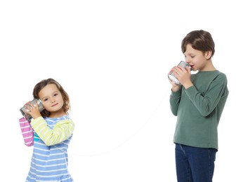 Boy and girl talking on tin can telephone against white background