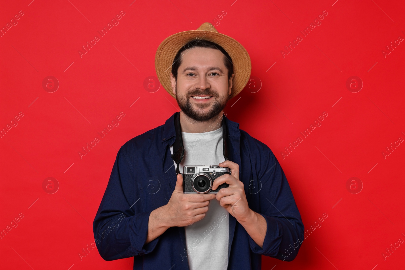 Photo of Traveller with vintage camera on red background