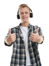 Photo of Happy man in headphones showing thumbs up on white background. Like gesture