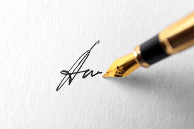 Photo of Fountain pen leaving signature on paper, closeup