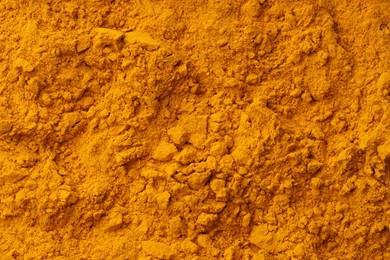 Photo of Aromatic turmeric powder as background, top view