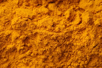 Photo of Aromatic turmeric powder as background, top view